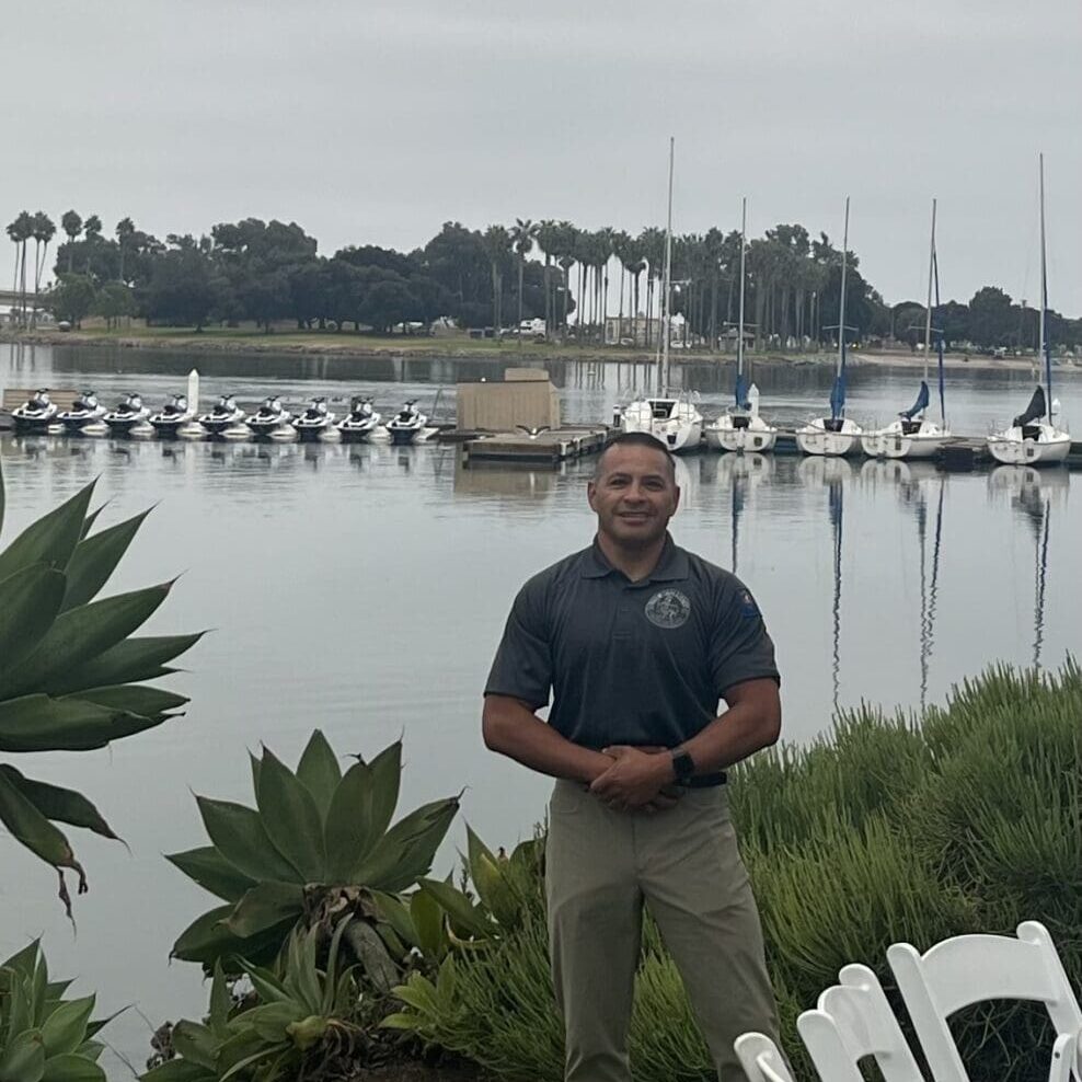 A man standing in front of some boats